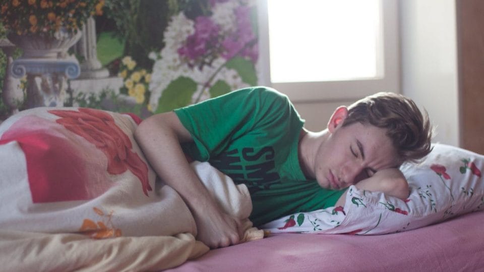 A Man Sleeping On Bed To Study In Less Time For Exams