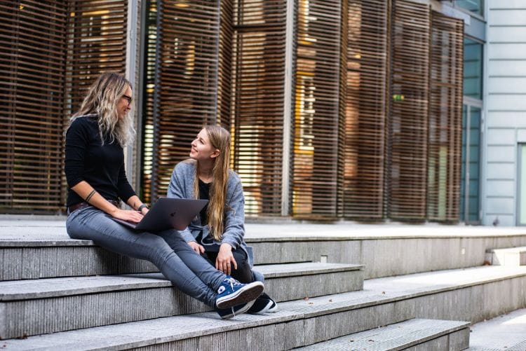 two girls smiling and asking questions