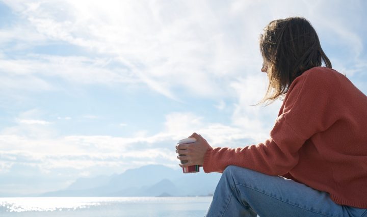 A Girl Sitting Next To Water
